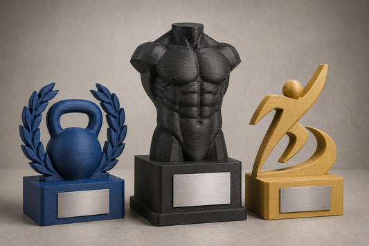 Tre trofei in PLA stampati in 3D per una gara di fitness e bodybuilding, con linee dei layer visibili e basi rettangolari
